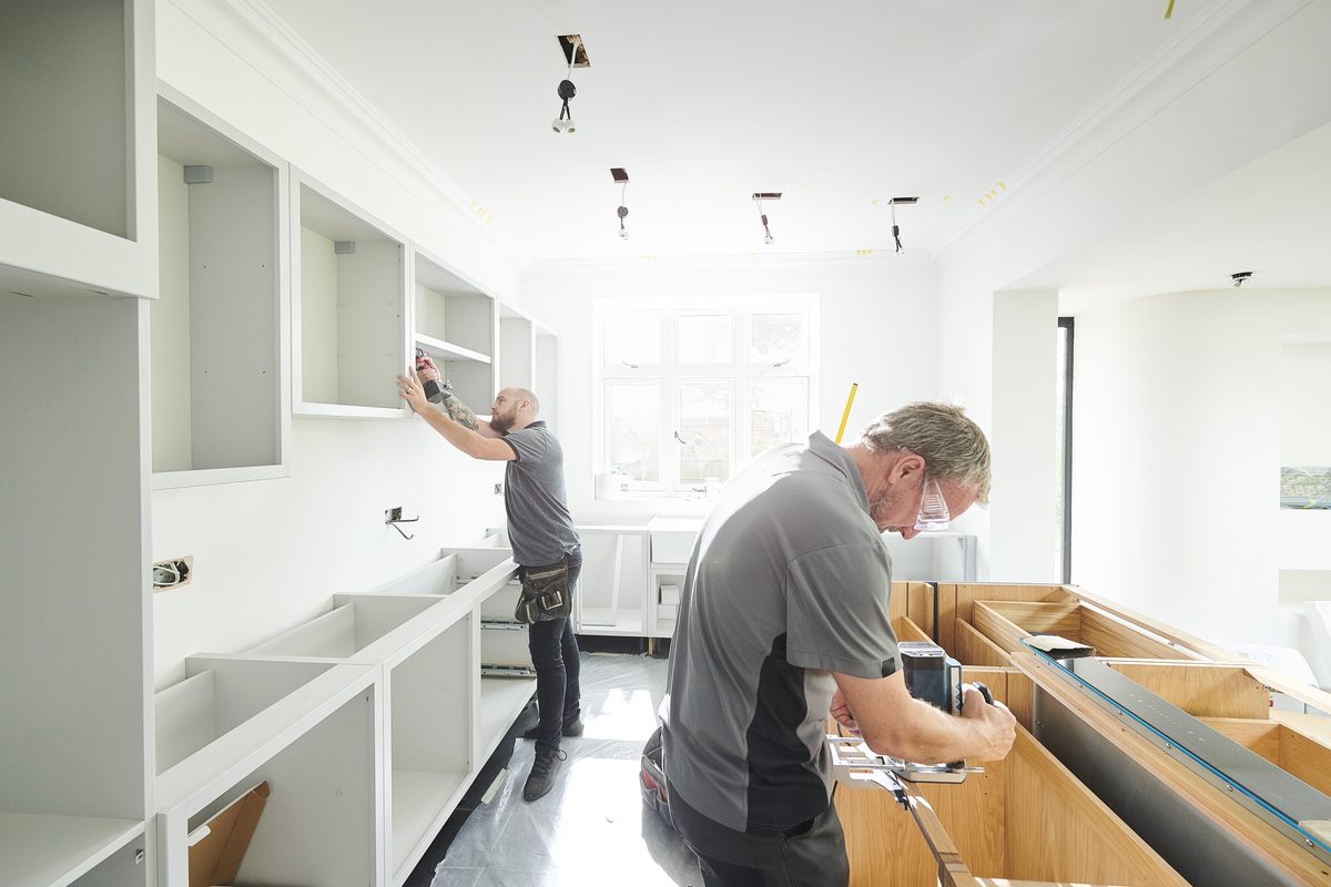 Joiners fitting a new kitchen during a refurbishment
